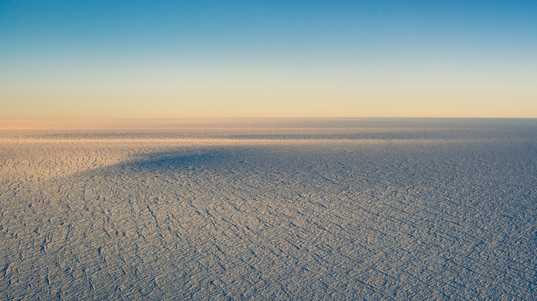 Sun is setting over an Antarctic plateau