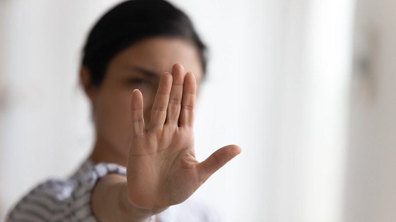 Woman raising hand to say 'stop'