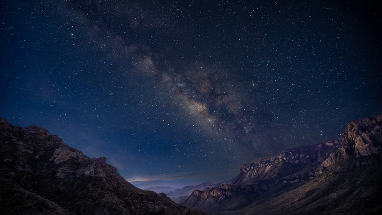 The Milky Way in the sky above a mountainous valley