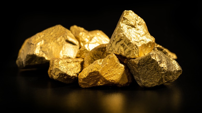 Pieces of gold ore on black background