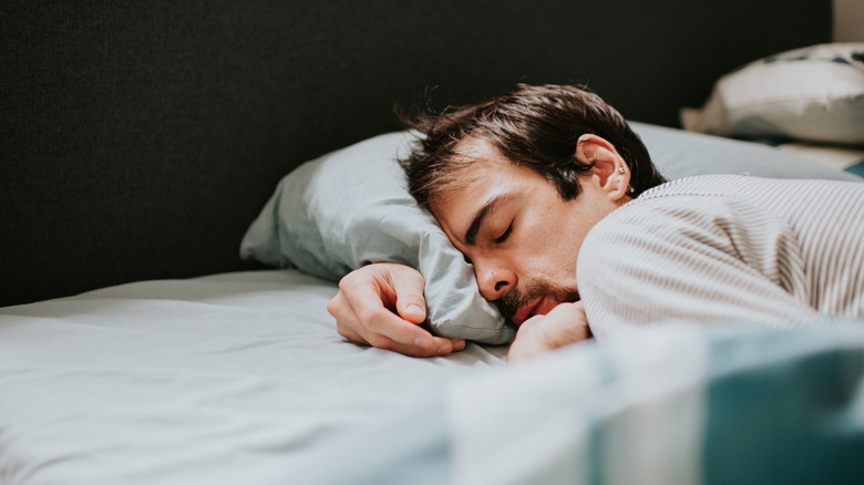 A man lies in a bed asleep