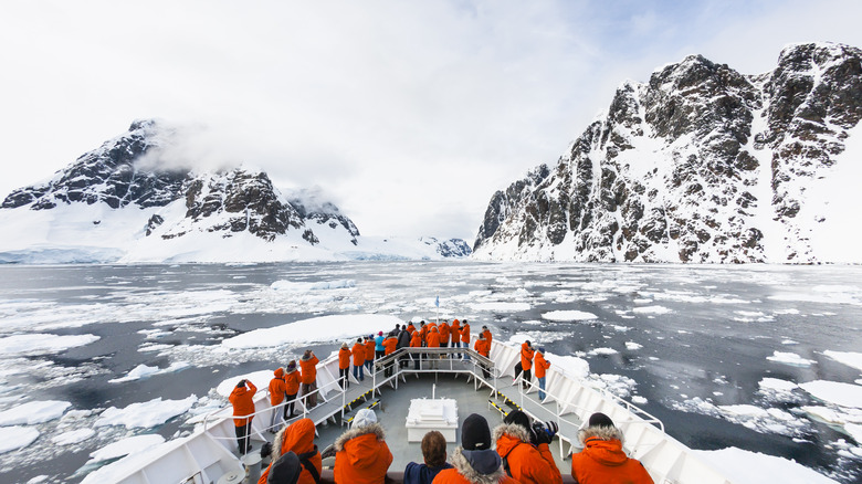 Tourists viewing Antarctic Peninsula from the bow of a ship