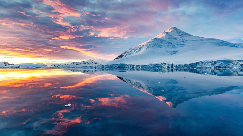 Antarctica's landscape reflects in the water at sunrise/sunset