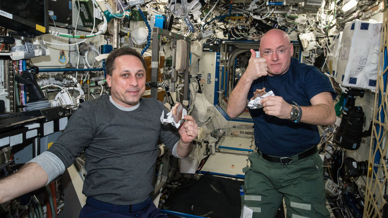 Two astronauts eating aboard the ISS