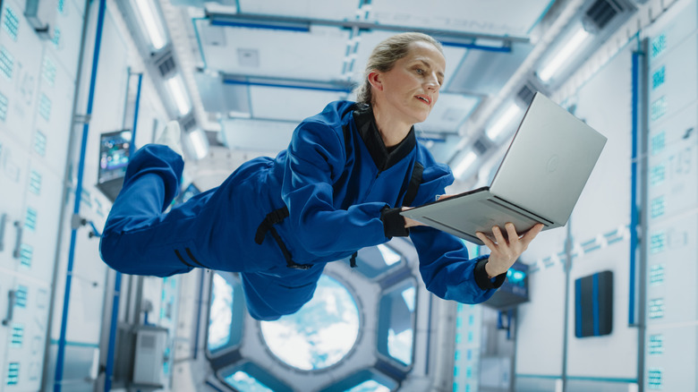 Female astronaut using a laptop