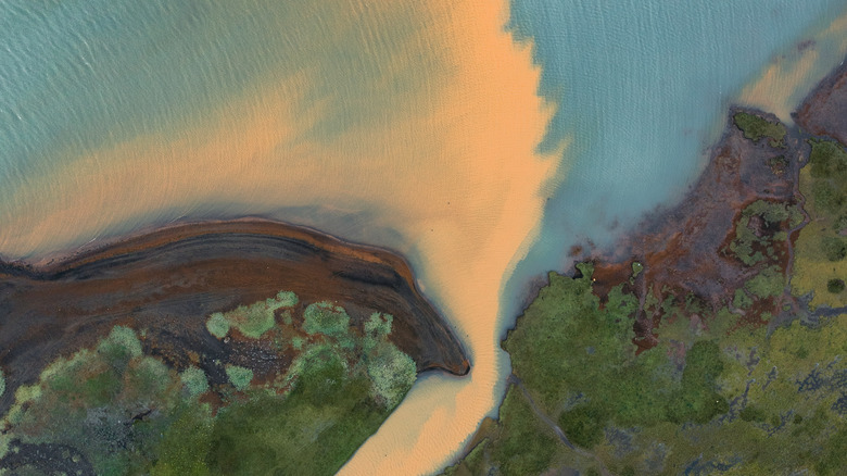 An aerial view of river sediment mixing with the sea