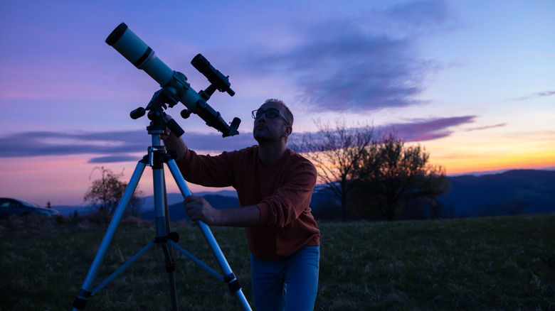 man setting up a telescope