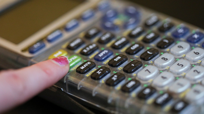 Finger reaching out for button on calculator