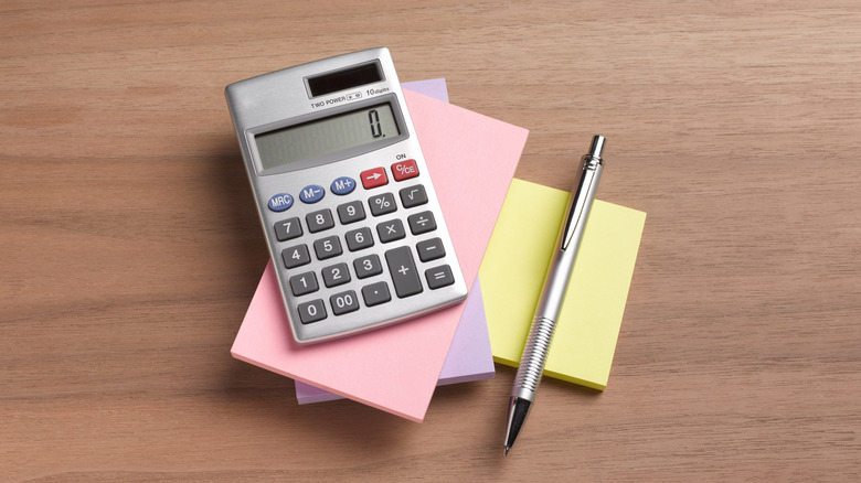 Calculator and pencil on stack of notepads