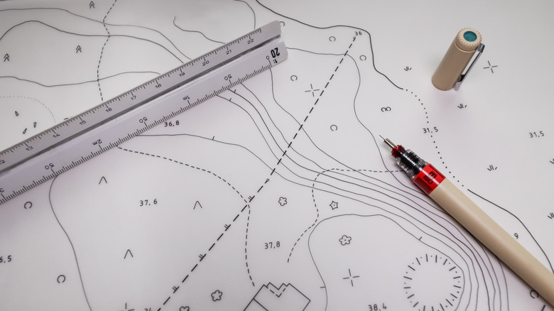 Pen and ruler sitting on topographic map