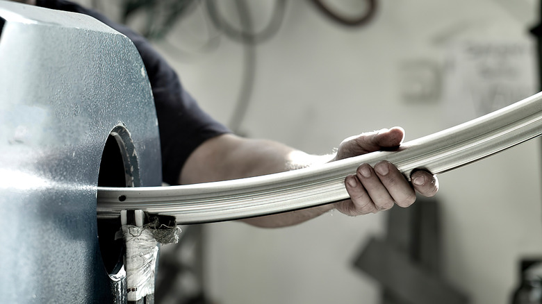 Person bending a metallic beam with machinery