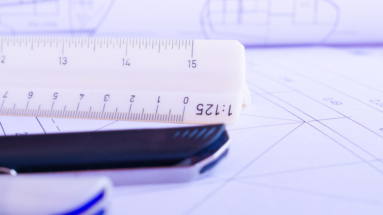 Triangular ruler standing on blueprints