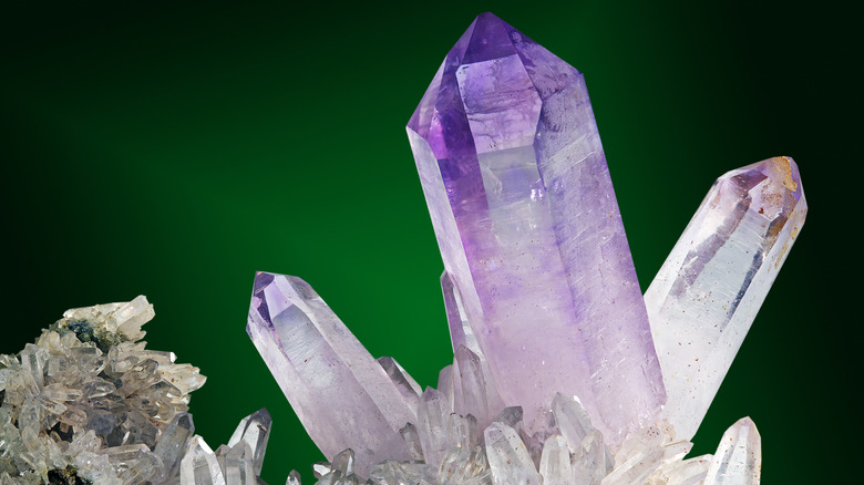 Close up of amethyst crystals on green background