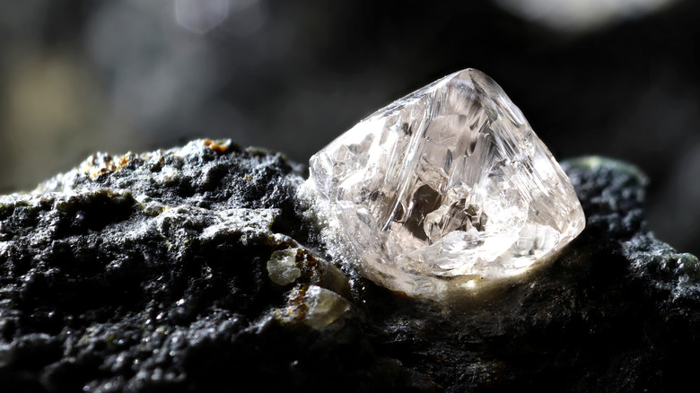 A natural diamond is shown nestled in black Kimberlite