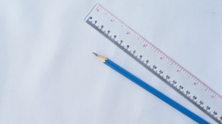 A standard ruler and a straight pencil white background