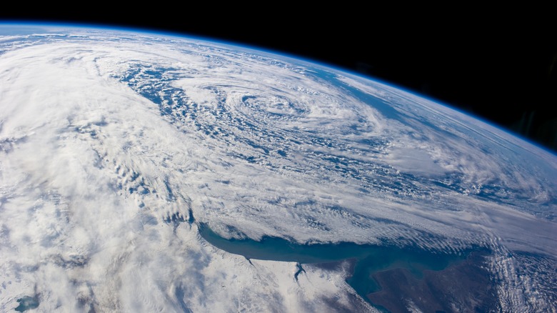 A satellite image of Earth from space with the Earth's curvature and atmospheric systems visible