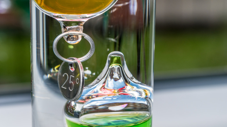 Close up of yellow and green liquid in Galileo thermometer