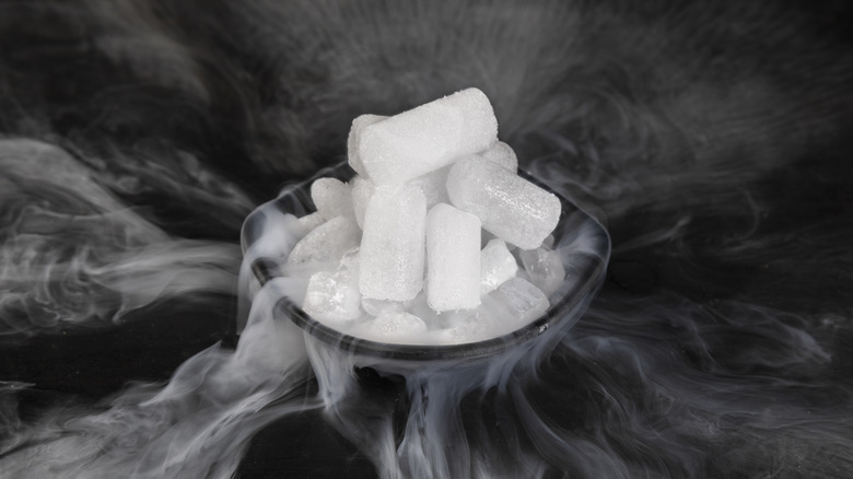 Dry ice sublimating in a bowl on black background