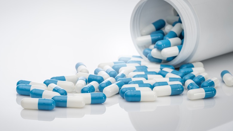 Blue and white capsules spilling out of tube