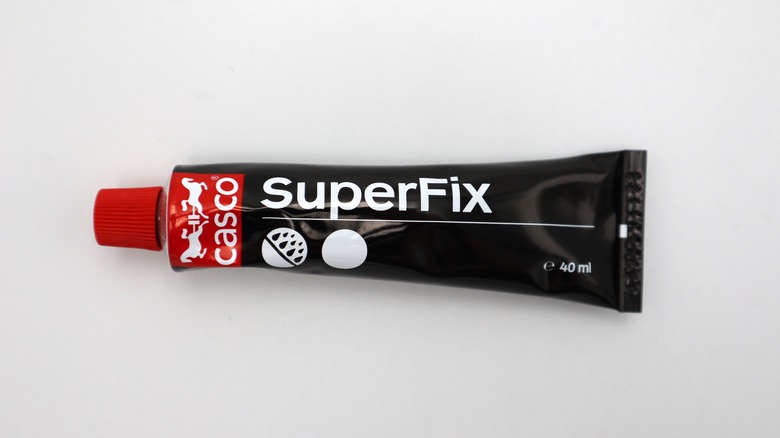 Black tube of super glue on white background