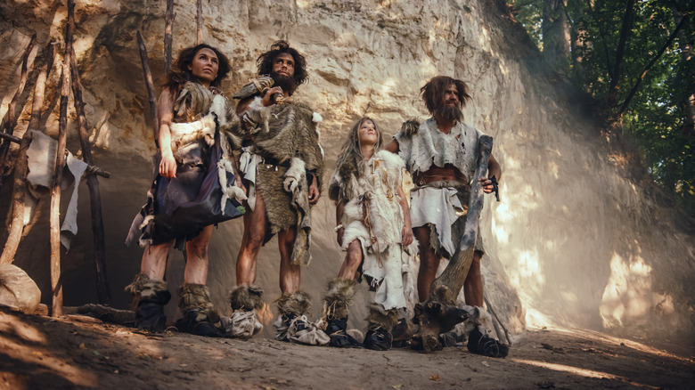 Neanderthals models in front of cliff face