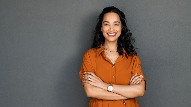 Young woman smiling with her arms folded