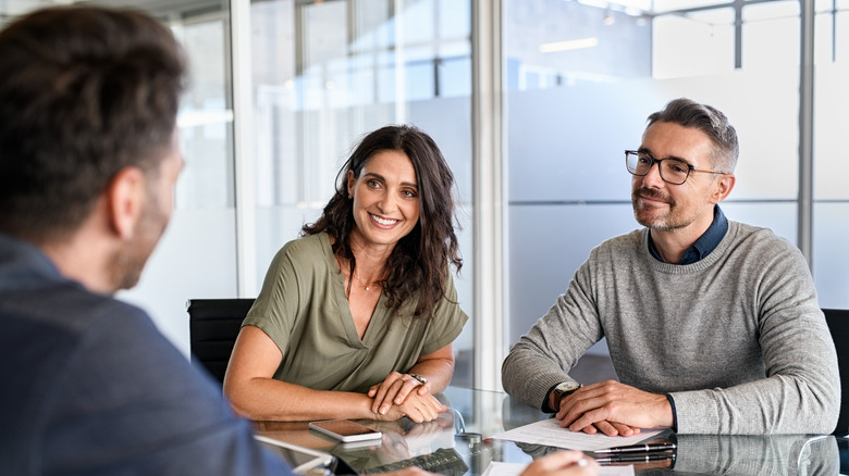 Two colleagues listening to another workmate