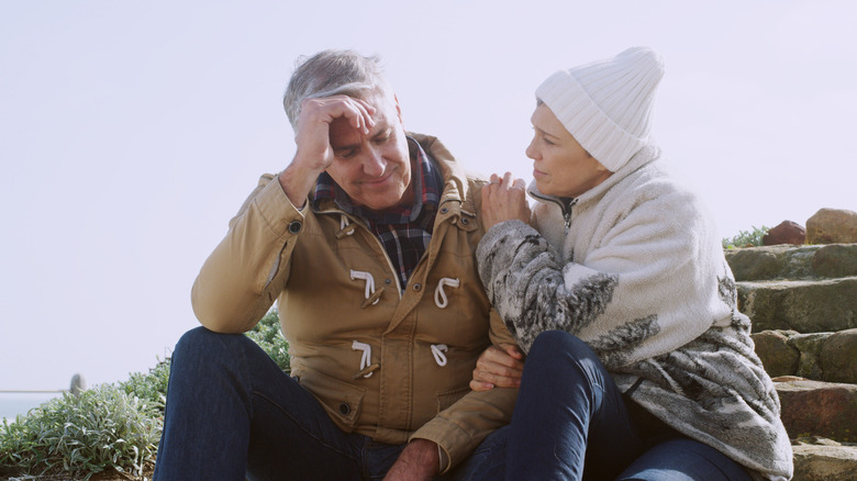 Woman comforting man outdoors