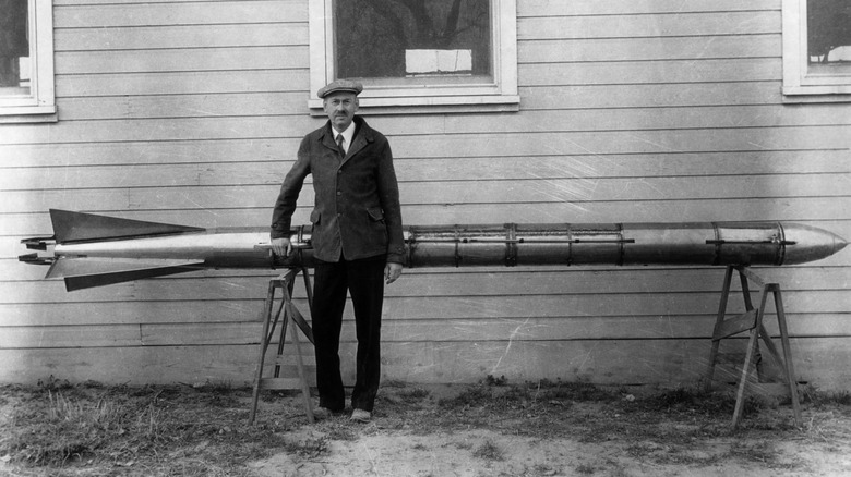 Robert H. Goddard standing with successfully tested rocket outside of his Roswell workshop in 1935