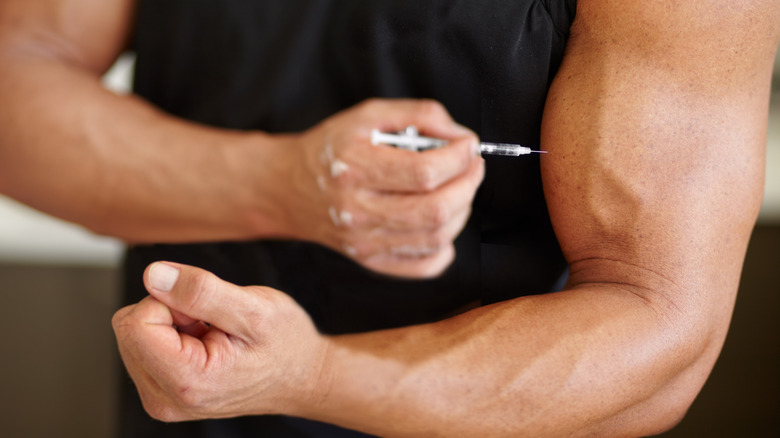 Bodybuilder injecting into his arm