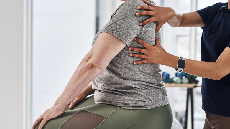 A physical therapist working on a patient's back muscles