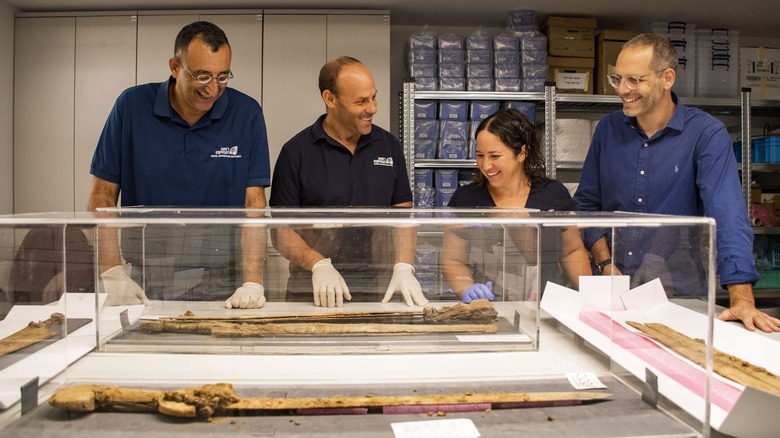 Amir Ganor, Dr. Eitan Klein, Oriya Amichay, and Dr. Asaf Gayer observe ancient Roman swords in glass cases