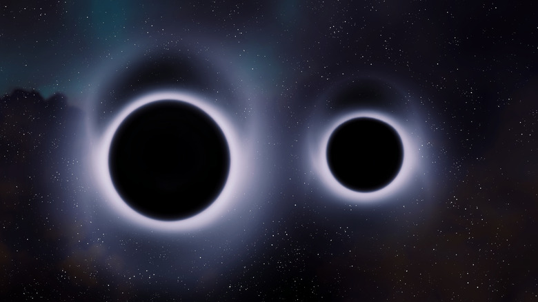 Two black holes are shown side by side in space with glowing white light surrounding each