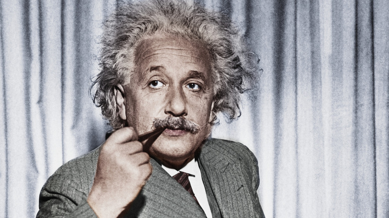 Albert Einstein calmly smokes a pipe, though his breakthroughs in physics were exciting.