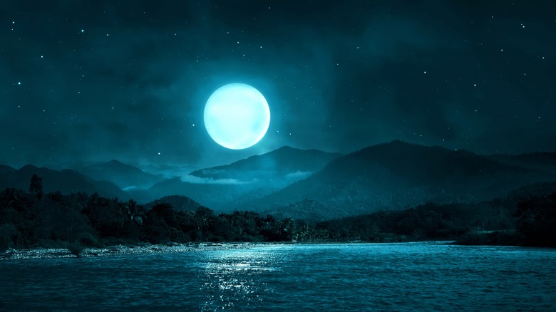 full moon rising over a lake