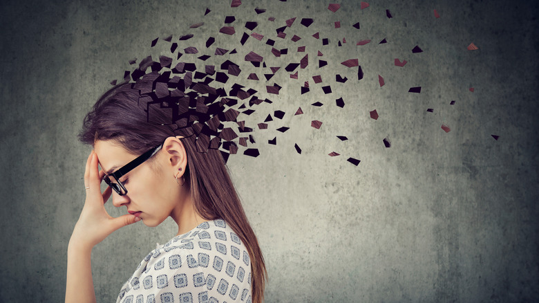 Depiction of young woman's head floating away in pieces to symbolize memory loss