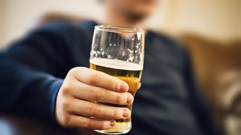 Person holding a glass of beer