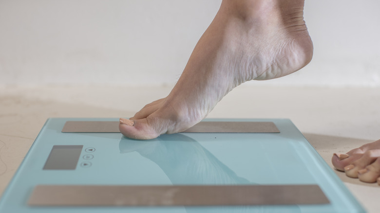 A foot stepping on to a bodyweight scale