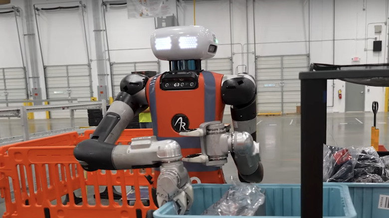 Agility Robotics' Digit robot holds a crate while working in a factory