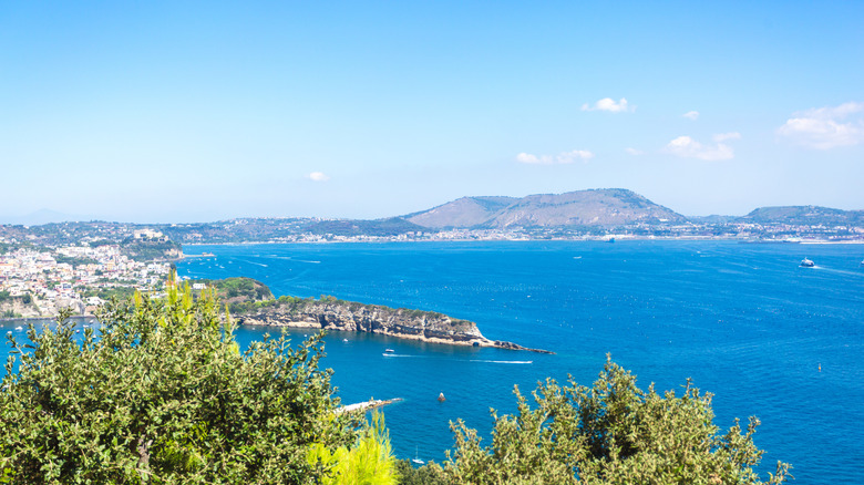 A body of water ringed by hills and a seaside town