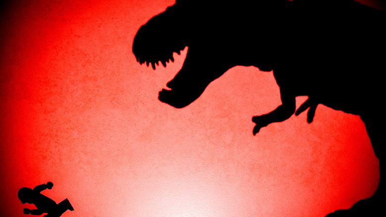 Silhouette of T-Rex chasing a human