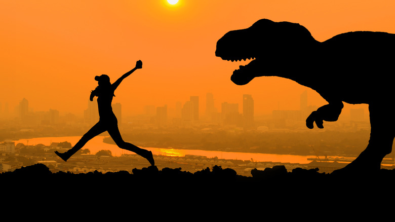 Human running from T-Rex with city in background