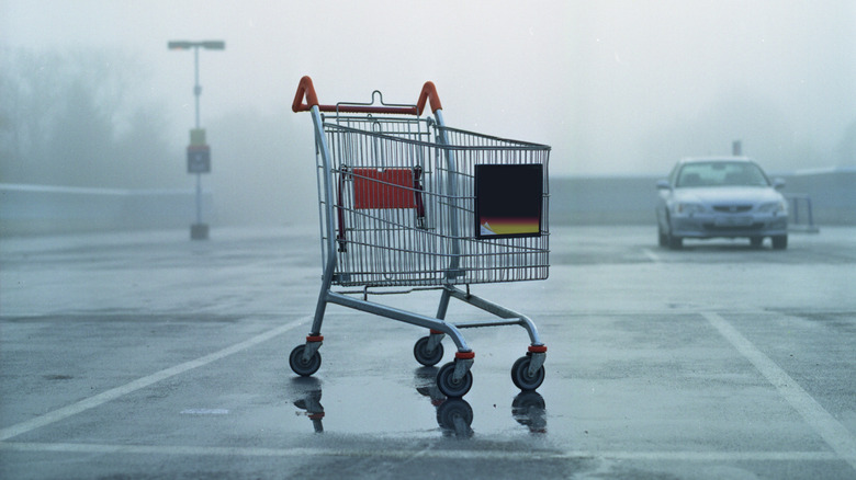 Shopping cart abandoned in rainy lot