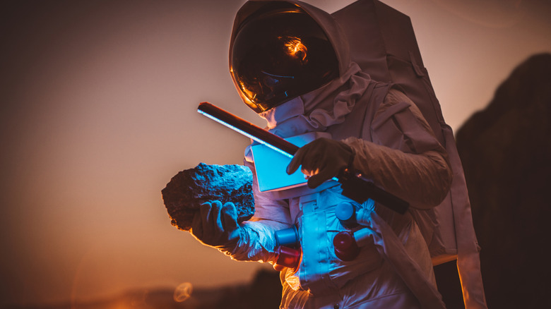 Astronaut examining rock