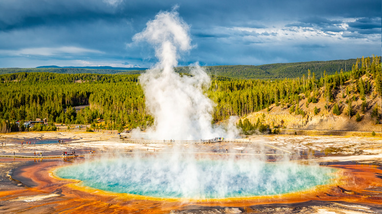 Steam rises from the Grand Prismatic Spring and Excelsior Geyser Crater in the Yellowstone caldera as visitors walk the boardwalk in between