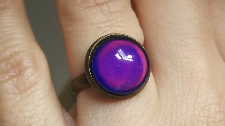 Purple mood ring on finger