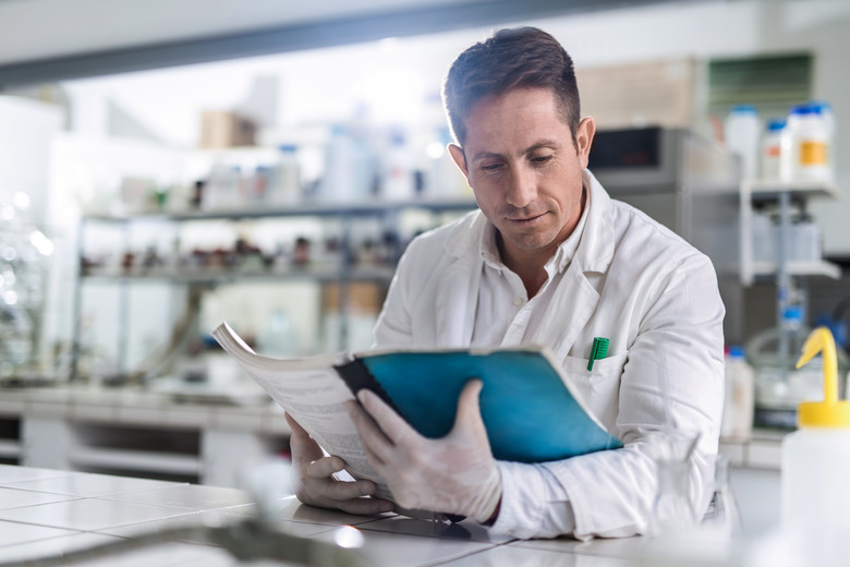 Male chemist reading medical data in laboratory.