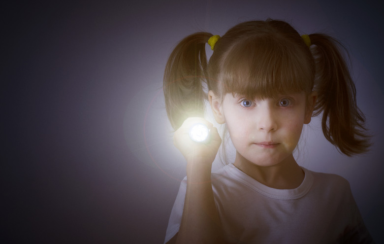 child in the dark with a flashlight