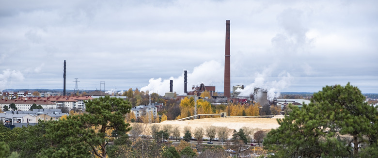 Old paper mill in europe. Finland. Red brick buildings. Tall brick pipes smoke. Polluted nature, ecology problems. Panoramic view