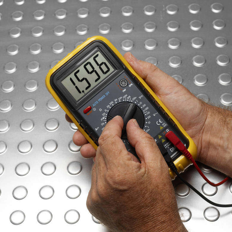 Hands using voltage meter